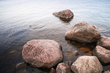 Coastal red granite stones lay in still lake
