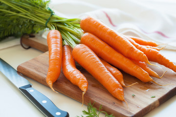 raw carrot vegetable on wooden chopping board - obrazy, fototapety, plakaty