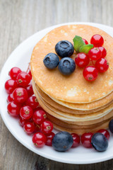 Stack of pancakes with blueberry and fresh berry.