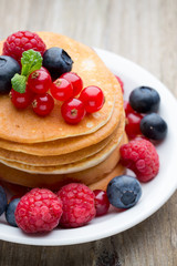 Stack of pancakes with blueberry and fresh berry.