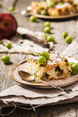 Light homemade semolina cake with gooseberries and apples on a vintage wooden background and homespun napkins 