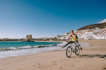 Obraz premium carefree woman with bicycle riding on beach sand having fun and