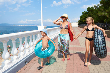 Family on vacation at sea walk along promenade