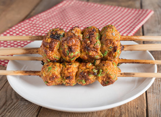 Thai curried fish cake grill on white plate.