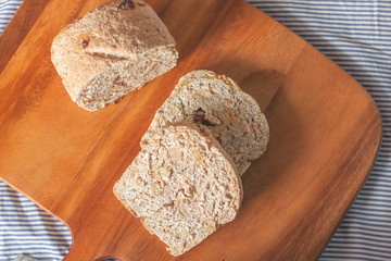 whole wheat bread is sliced on the wooden plate