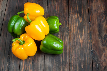 yellow and green paprika on wood background