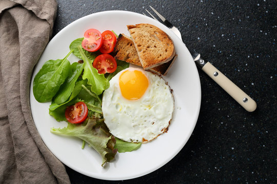 Fried eggs with vegetables salad