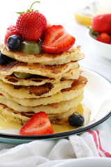 Stack of breakfast pancakes with fruits and sauce