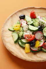 Fresh Greek salad on wooden plate