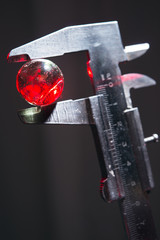 caliper measuring glass ball on dark background