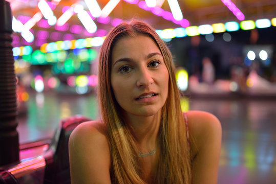 Blonde girl driving car on attraction