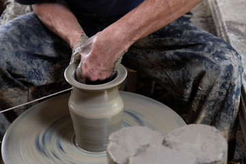 Potter shaping clay on the pottery wheel