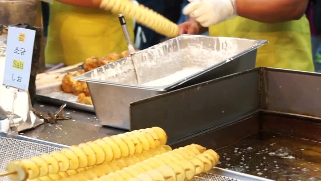 Famous street food around the world. Twist spiral potatoes. Dipping potato in flour and fried in oil