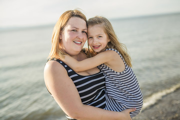 Mother and daughter on the beach side having fun