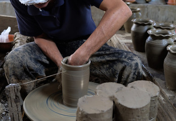 Potter shaping clay on the pottery wheel