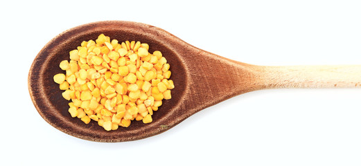 Raw split peas in a wooden spoon