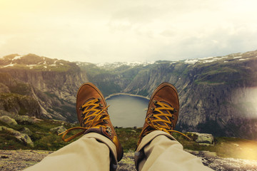 Traveler resting on a mountain plateau. POV view, legs close up on the background of mountain...