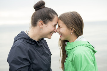 Fototapeta premium Family enjoying the rain and having fun outside on the beach a gray rainy