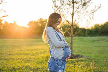 young happy pregnant woman relaxing and enjoying life in autumn nature