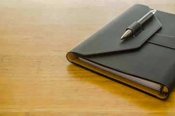 black leather organizer with pen