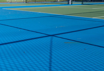 Obraz premium Abstract image of tennis court and tennis equipment. Light and shadow on tennis court. Daylight on a tennis court. Outdoors sport. Minimal art and design. 