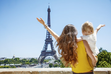 mother and daughter travellers rejoicing and looking at Eiffel t