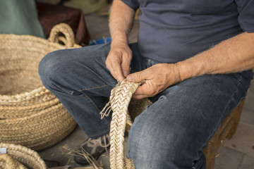 Fototapeta premium hand man weaving a wicker basket