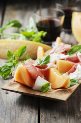 Antipasto with melon, mozzarella, ham and basil