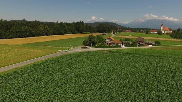 Camera flying back on a beautiful green field with mountain background