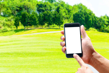 Hand using smartphone mobile in the vertical position, background blur of golf.