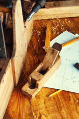Equipment carpenter on a wooden desk with plans