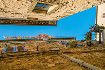View upwards of washing in narrow street in Montemerano, Tuscany - 117836575