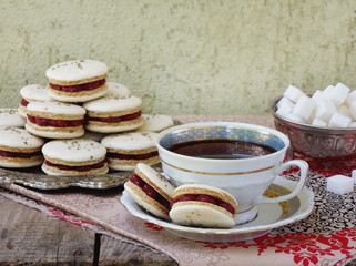 cup of espresso coffee and French macaroons dessert on wooden background