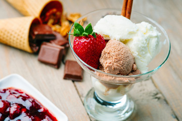 Ice cream sundae, chocolate, walnuts, jam and strawberry 
