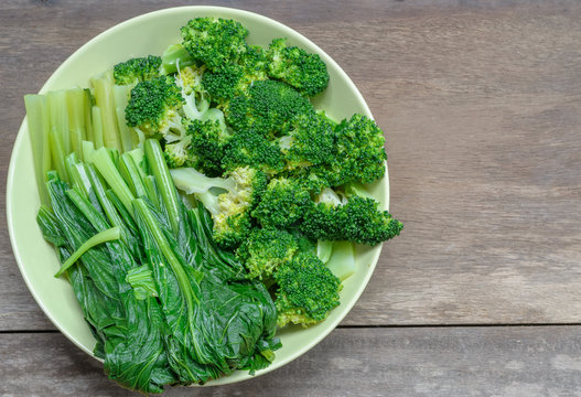 Broccoli and Bok choy on wood background.