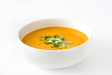 Pumpkin soup with cream and pumpkin seeds isolated on white background

