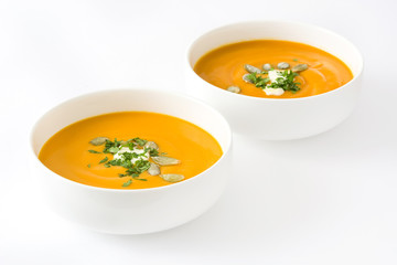 Pumpkin soup with cream and pumpkin seeds isolated on white background

