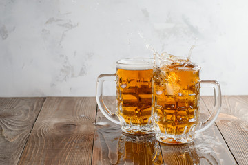 Two Oktoberfest beers splash on a wooden table