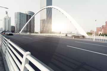 Fototapeta na wymiar urban traffic on bridge with cityscape in background