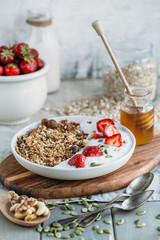 Homemade granola with fresh strawberry over vanilla yogurt. Healthy breakfast