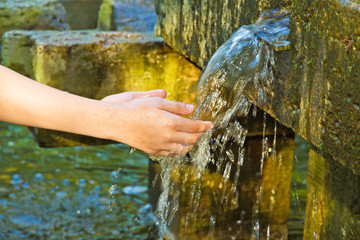 Kind beim Hände waschen an einem Brunnen