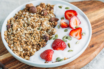 Homemade granola with fresh strawberry over vanilla yogurt. Healthy breakfast