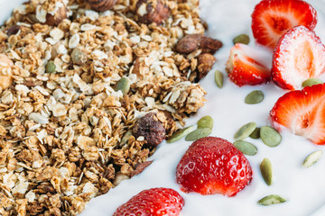 Homemade granola with fresh strawberry over vanilla yogurt. Healthy breakfast