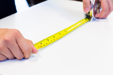 tape-measure in hand with white background