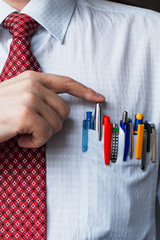 The elegant stylish businessman keeping a lot of colored pens in his breast pocket.