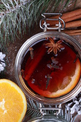 Christmas drink with orange fruit, anise, cinnamon and cloves on wooden table