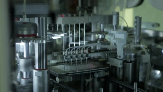 Modern automatic medical analyzer. Test tubes on robotic conveyor. Close up tracking shot.