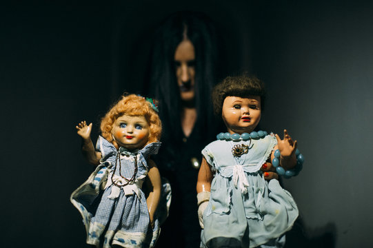 Spooky scene of two dolls in female hands