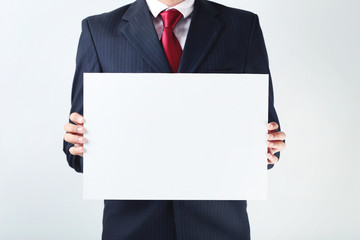 Businessman holding blank sheet of paper in his hands