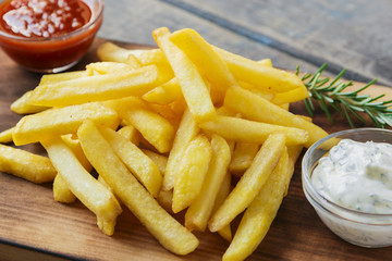 French fries with sauce on a cutting board